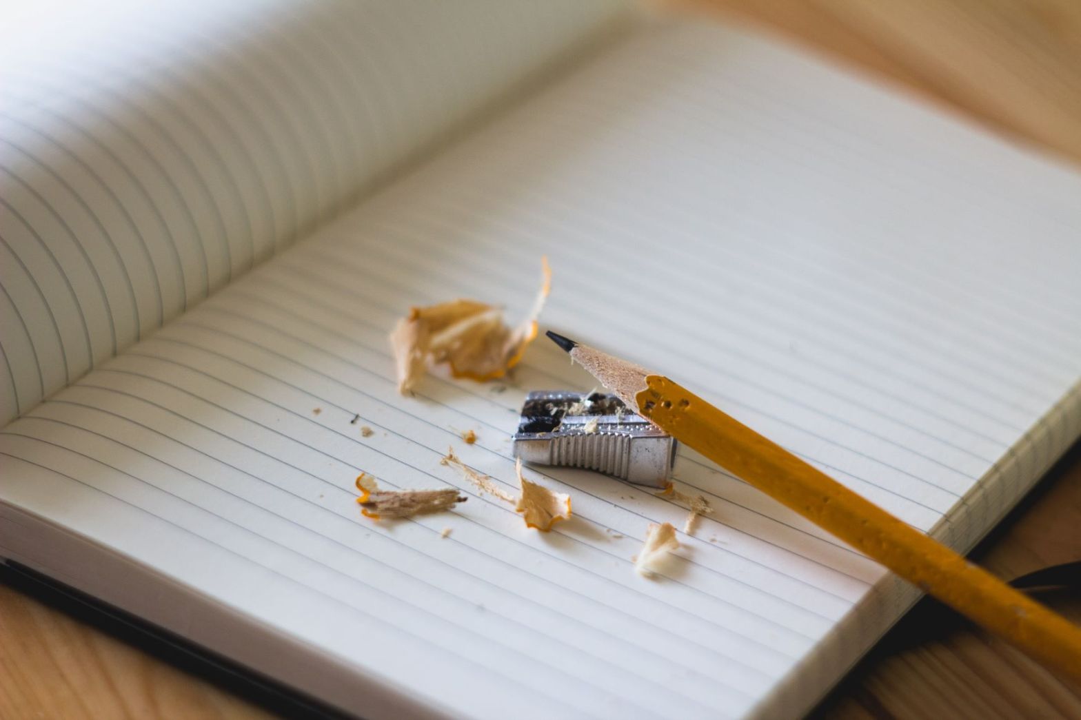 Blank notebook with newly sharpened pencil, sharpener and shavings